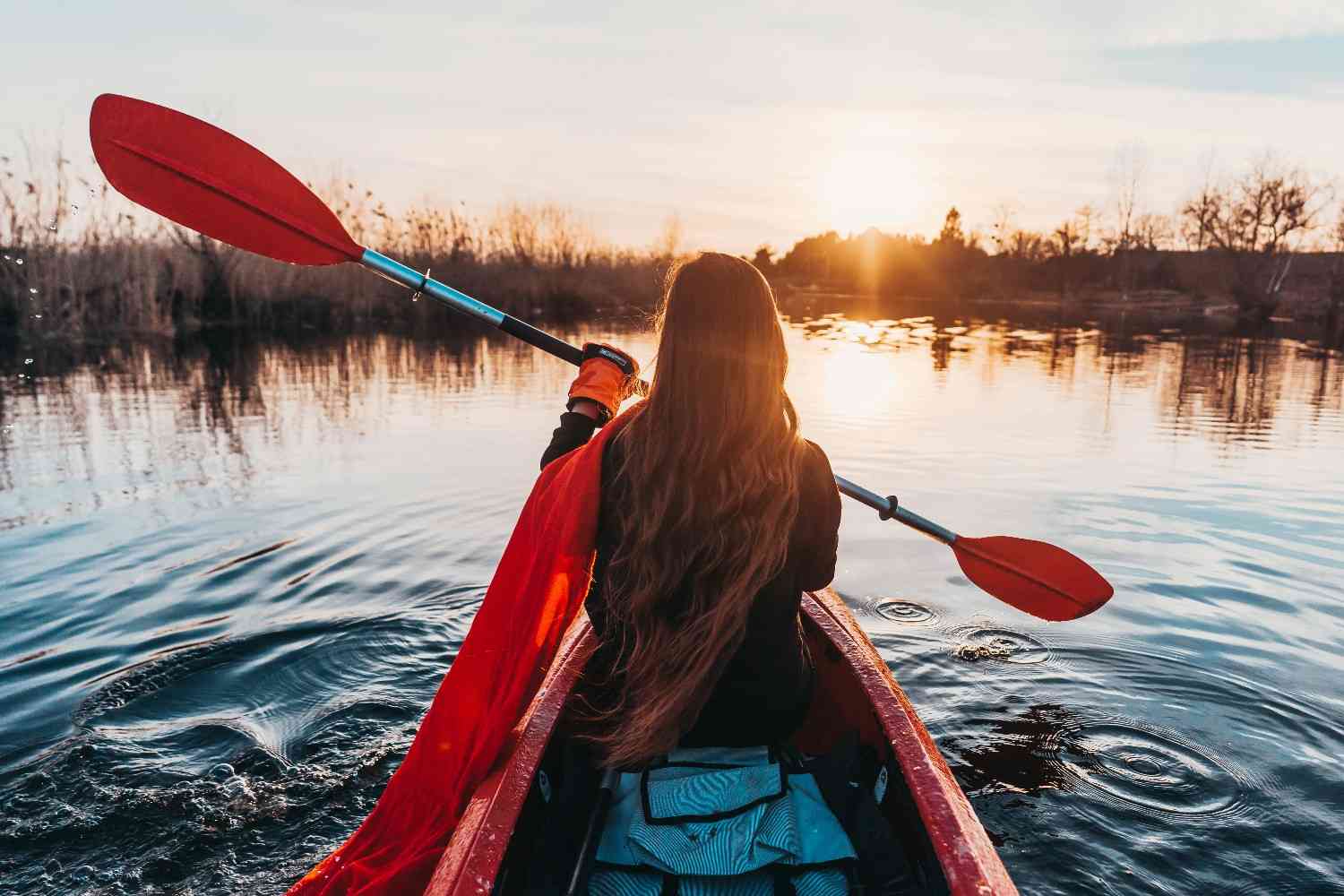 A woman kayaking on calm waters during a golden sunset, creating a peaceful yet adventurous moment that reflects some of the Fun Things to Do in Panjim.