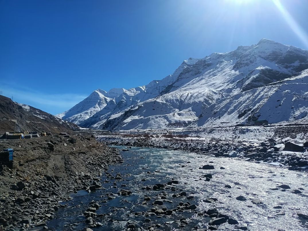 Snowy mountain valley with river during budget solo trip in India Towno